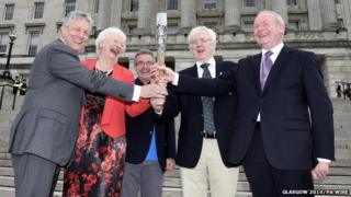 Queens Baton Relay of (left to right) Peter Robinson, Olympic champion Mary Peters, Chris Jenkins, Robert McVeigh and Martin McGuinness holding the Commonwealth Games Baton on the steps of Stormont, Belfast, Northern Ireland.