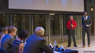 Two boys give a presentation in front of judges