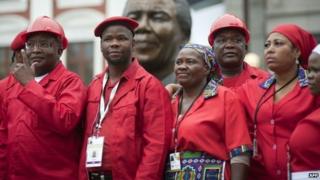 Members of the Economic Freedom Fighters(EFF) pose for a photo in front a bust of Nelson Mandela at the South African parliament on 21 May 2014