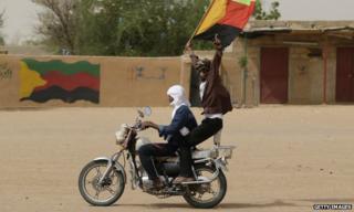 A Tuareg man waves the flag of the National Movement for the Liberation of Azawad (MNLA) in Kidal, northern Mali. File photo