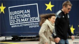 People walk in front of advert in Brussels (24 May)