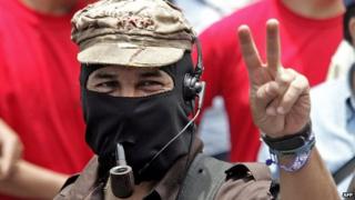 Subcomandante Marcos flashes the "v" sign as he takes part in a march in Mexico City, May 1, 2006.