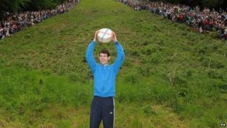Josh Shepherd, 19, from Brockworth, celebrates winning the Men's Downhill race in the Cheese Rolling on Cooper's Hill