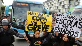 Striking teachers in front of Brazil football team's bus
