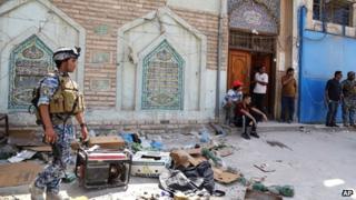 Iraqi security forces and civilians inspect the site of a suicide attack at a mosque in the Shorja market area in central Baghdad