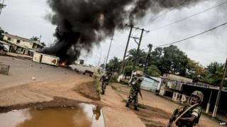 Burundian peacekeepers of the African-led International Support Mission to the Central African Republic (MISCA) patrol near a barricade of burning tyres erected in the Bea-Rex district of Bangui on 29 May 2014
