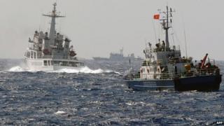 File photo: A China Coast Guard ship (left) blocks the way of a Vietnam Coast Guard ship near to the site of a Chinese drilling oil rig (right, background) being installed at the disputed water in the South China Sea, 14 May 2014