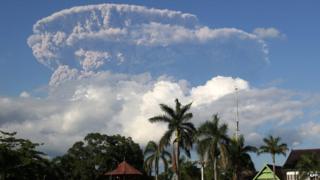 In this photograph taken on 30 May, 2014, a giant cloud of ash and steam rise from erupting Sangeang Api volcano seen from Bima town on Sumbawa island