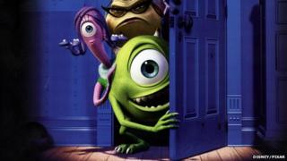 A publicity still from Monsters Inc showing a green monster with one big eye peering from behind a wardrobe door.