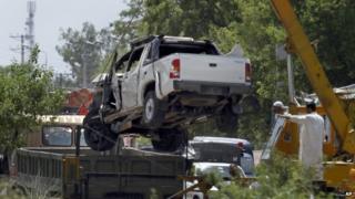 A damaged vehicle that carried military officers is removed from the site of suicide bombing on the outskirts of Fateh Jang, some 36 km (22 miles) southwest of Islamabad, Pakistan, Wednesday, June 4, 2014.