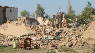 Pakistani tribesmen clear rubble and belongings from their destroyed houses following Pakistan military airstrikes against suspected Taliban hideouts in Miranshah in North Waziristan on 24 May 2014.