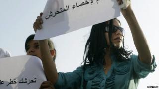 A female protester holds a sign reading "Yes to castrating the sexual harasser" in Cairo (11 June 2014)