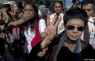 A woman in Thailand doing a three-finger salute