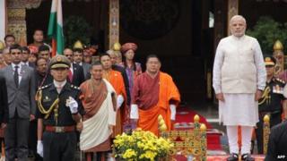PM Narendra Modi looks on with Bhutanese officials during a traditional "chhipdrel" ceremony and to greet a guard of honour in Thimphu on June 15, 2014.