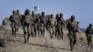 In this Tuesday, Nov. 17, 2009 file photo, Pakistani troops walk on a hilltop post near Ladha, a town in the Pakistani troubled tribal region of South Waziristan along the Afghan border.