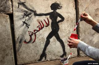 Graffiti showing a woman and reading in Arabic: 'No to Sexual Harassment' on a wall outside the presidential palace in Cairo