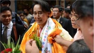 Myanmar opposition leader Aung San Suu Kyi is welcomed at a Buddhist monastery where she worked as an English teacher in 1973 in Kathmandu, on 16 June 2014.