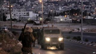 Israeli soldiers take part in an arrest operation in the West Bank town of Nablus early on 18 June 2014