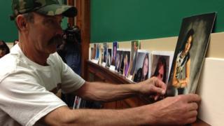 Randall Rademaker puts up a picture of his daughter, Amy Rademaker, w