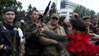Pro-Russian rebels receive flowers after taking an oath of allegiance