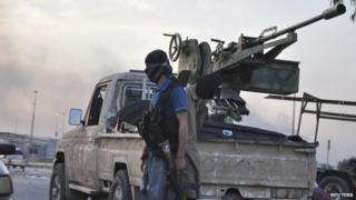 Isis fighter stands guard at an Iraqi checkpoint