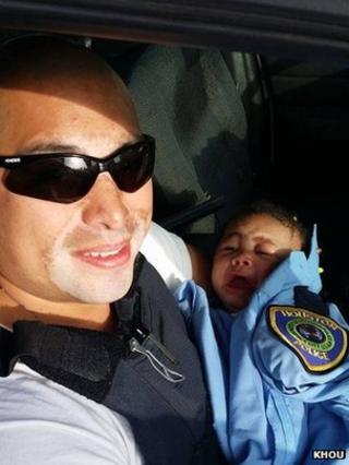 Officer Albert Pizana holds Genesis Haley