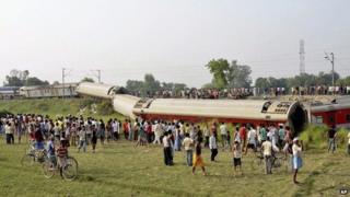 People gather around a passenger train that derailed in Bihar, near Chhapra town, India, Wednesday, June 25, 2014