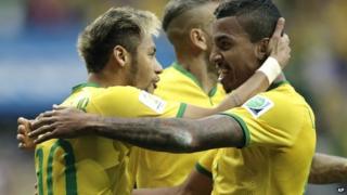Brazil's Neymar celebrates with Luiz Gustavo and Dani Alves after scoring against Cameroon
