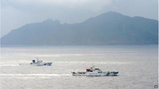 In this 23 April 2013 file photo, a Japan Coast Guard vessel (left) sails along with a Chinese surveillance ship near the disputed islands called Senkaku in Japan and Diaoyu in China in the East China Sea.