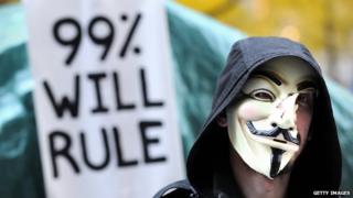 An Occupy Wall Street protestor holds up a sign that reads, "99% will rule".