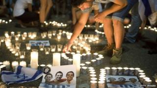A mourner lights candles for the murdered teenagers in Tel Aviv