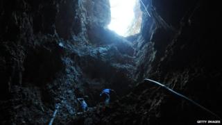 Gold miners look for gold inside an informal mine in the mountains of San Juan Arriba, 130 km south of Tegucigalpa, on 7 February, 2012