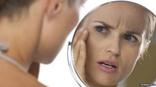 Woman looking in mirror