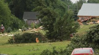 A fireman walks through a debris field off Goff Road in Smithfield follow a storm 8 July 2014
