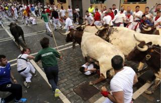 A bull running over Tom Hadfield in Pamplona, Spain, on 8 July 2014
