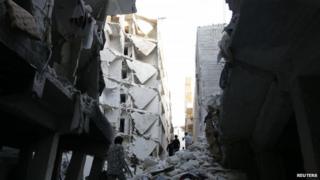 People walk through the rubble of collapsed buildings in Aleppo, Syria