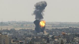 Smoke and flames are seen following what witnesses said was an Israeli air strike in Gaza City on 16 July 2014