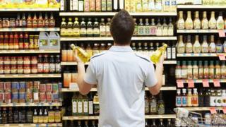 A man stares at shelves in a grocery store.