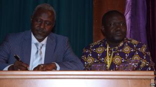 Exiled Centrafrican former general and representative of the Seleka opposition coalition Mohamed Moussa Dhaffane (L) and Patrice-Edouard Ngaissona, former Central African Youth and Sports Minister and self-declared political coordinator for the Anti-Balaka Christian militia sign a cease-fire agreement during a forum gathering key players in the Central African conflict, on July 23, 2014, in Brazzaville
