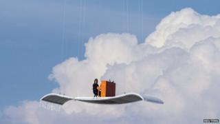 German pianist Stefan Aaron plays an orange piano on a "flying carpet" platform suspended from a helicopter, over Munich airport