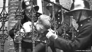 Boy with head stuck in railings