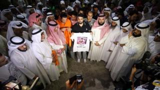 Supporters of Kuwaiti opposition leader and former MP Mussallam al-Barrak (portrayed on the shirt) take part in a demonstration to ask for his release