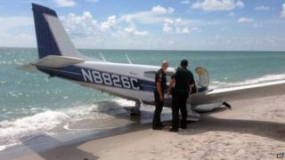 Photo provided by the Sarasota County Sheriff's Office shows emergency personnel at the scene of a small plane crash in Caspersen Beach in Venice, Florida 27 July 2014