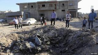 People look at the wreckage of a government MiG warplane which crashed during Tuesday's fighting, in Benghazi, Libya, 29 July 2014