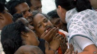 Congress party president Sonia Gandhi with the grieving parents on 18 July 2004