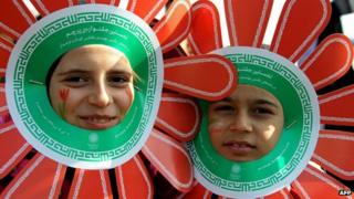 Iranian children wearing paper flowers