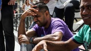 An immigrant cries as he takes part in a demonstration outside court in the city of Patras