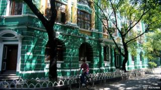 A man cycles past one of the old colonial buildings in Shamian Island