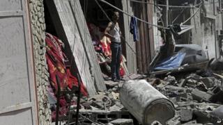 A Palestinian stands in front of his family house destroyed in an Israeli attack in the Bureij refugee camp in the central Gaza Strip