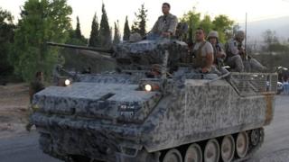 A Lebanese army's armoured personal carrier (APC) drives to the entrance of the town of Arsal in the Bekaa valley by the Syrian border on 2 August 2014
